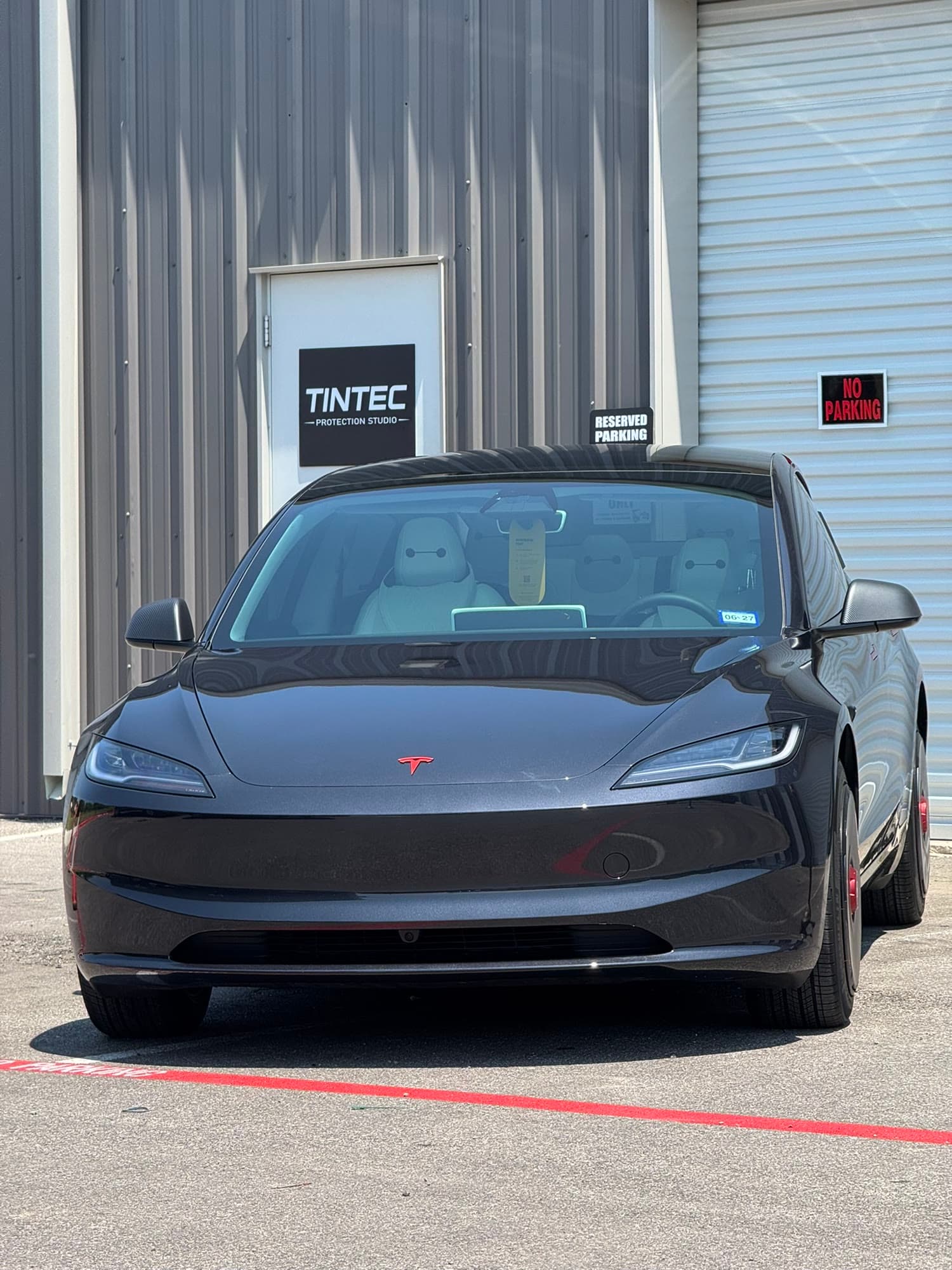 Tesla Model 3 parked in front of the TINTEC Protection Studio shop entrance