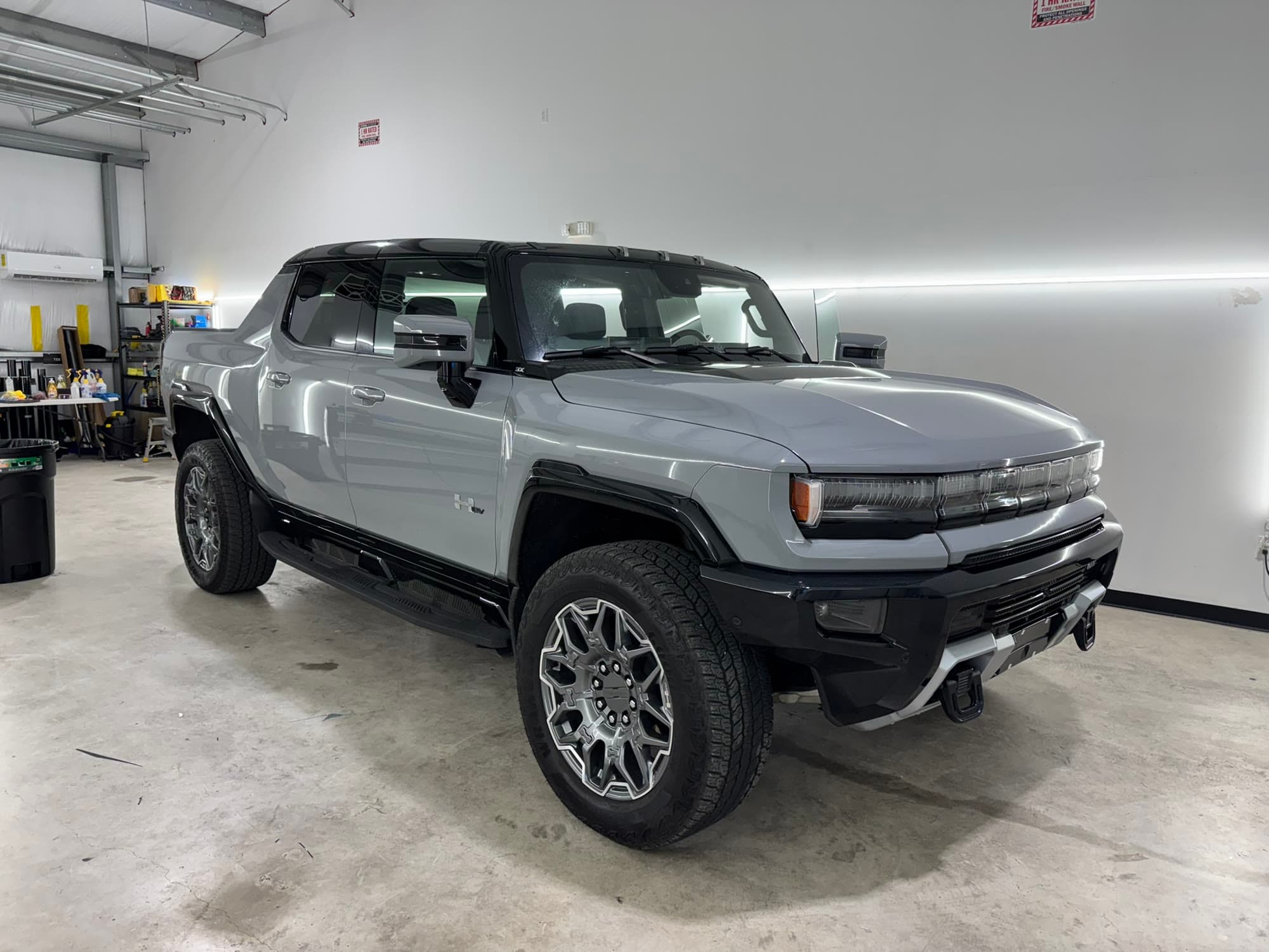 Grey GMC Hummer EV pickup with tinted windows, finished and staged in the TINTEC bay