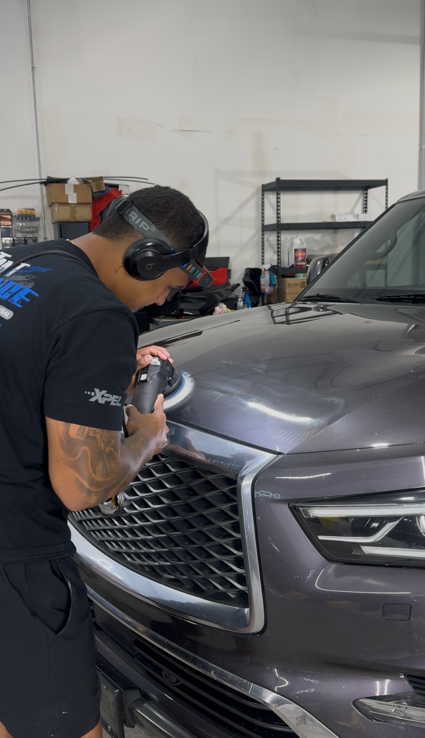 TINTEC technician machine polishing the front end of a Jeep Grand Wagoneer before coating